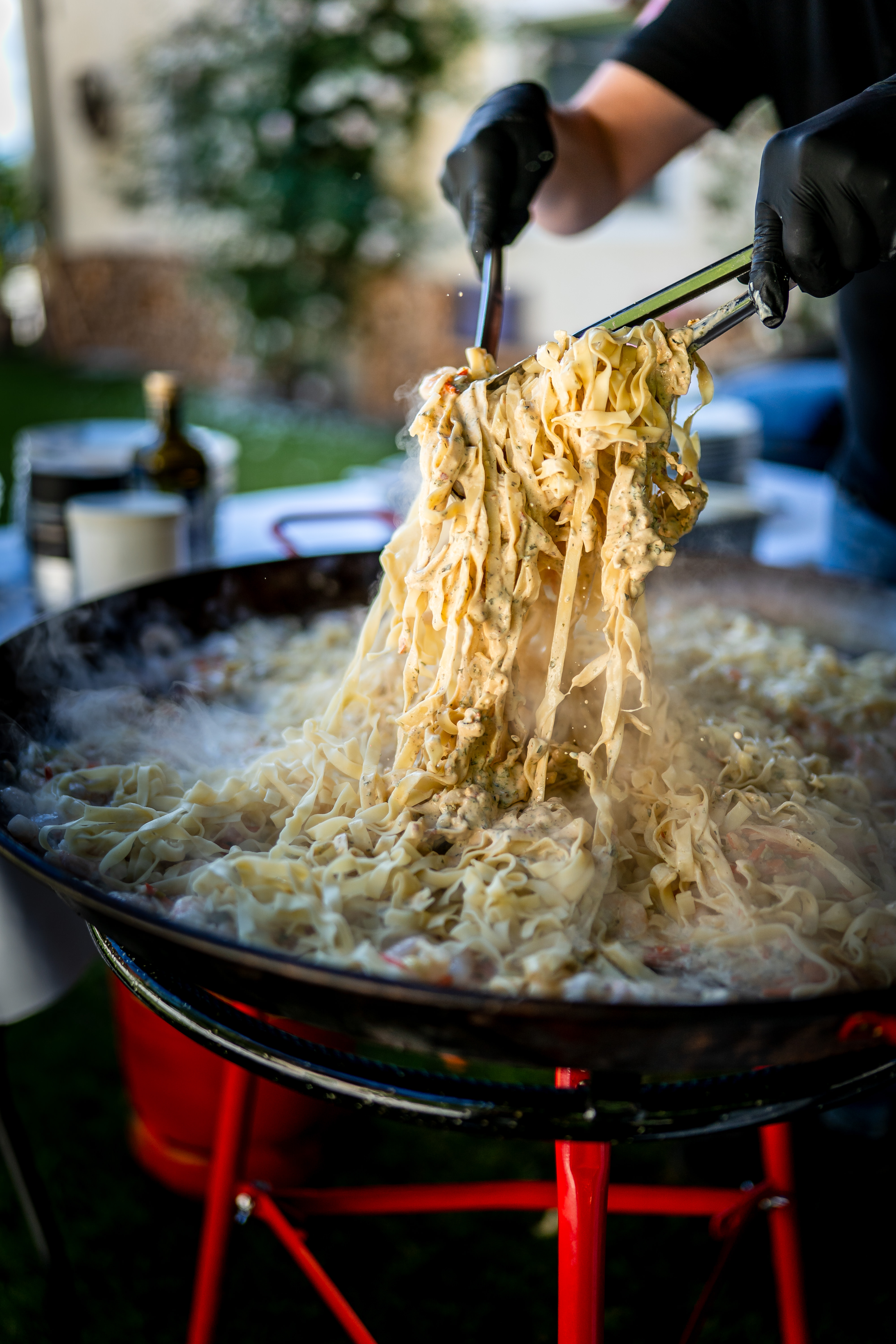 Dampfende Pasta wird aus der Riesenpfanne gehoben