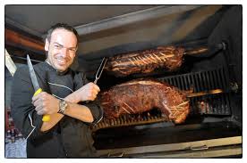 Roland Florianz tranchiert Spanferkel am Grill